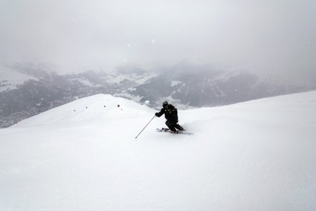 Davosin Jakobshorn-hiihtoalueen reunimmainen rinne kulkee harjanteena suoraan kaupunkia kohti. Vastapäinen Parsenn jää lumipilven taakse.